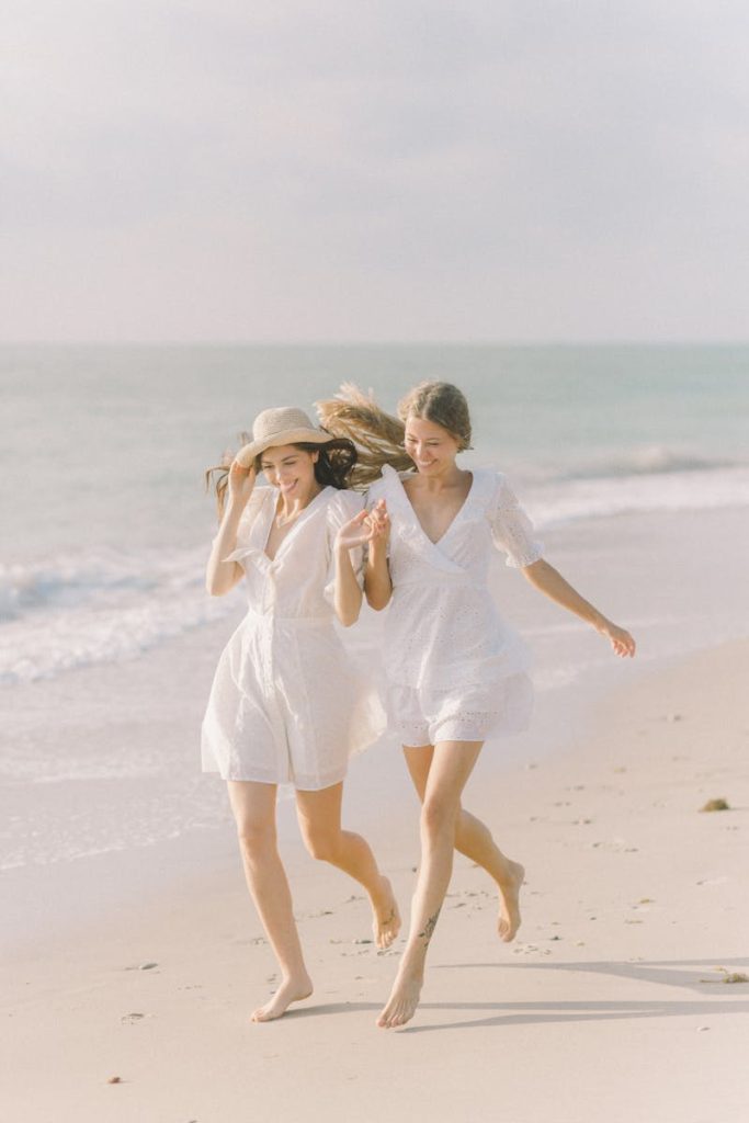 Dos mujeres sonrientes y felices divirtiéndose en la playa, porque tienen una vida maravillosa